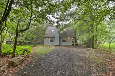 a house in the woods with a dirt road at 7 Mi to Lake Harmony Home with Furnished Deck! in Albrightsville