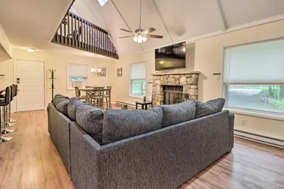 a living room with a couch and a fireplace at 7 Mi to Lake Harmony Home with Furnished Deck! in Albrightsville