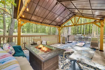 a patio with a fire pit on a deck at Game Room and Home Theater! Immaculate Poconos Lodge in Albrightsville