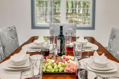 a table with a plate of grapes and a bottle of wine at Game Room and Home Theater! Immaculate Poconos Lodge in Albrightsville