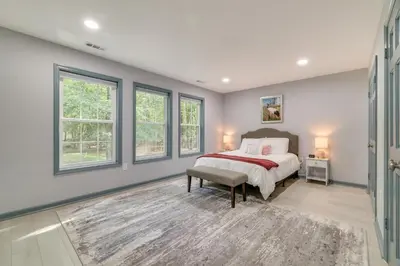 a bedroom with a bed and windows at Game Room and Home Theater! Immaculate Poconos Lodge in Albrightsville