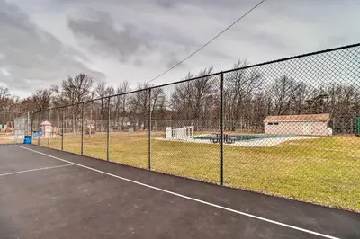 a tennis court with a chain link fence at Game Room and Home Theater! Immaculate Poconos Lodge in Albrightsville