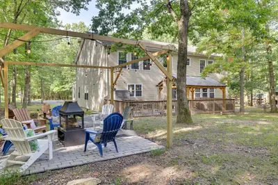 a patio with chairs and a grill and a house at Game Room and Home Theater! Immaculate Poconos Lodge in Albrightsville