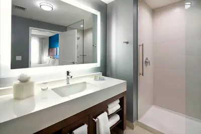 a bathroom with a sink and a mirror and a shower at Residence Inn by Marriott Secaucus Meadowlands in Secaucus