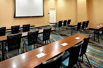 a conference room with tables and chairs and a screen at Residence Inn by Marriott Secaucus Meadowlands in Secaucus