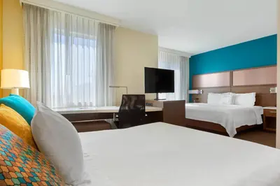 a hotel room with two beds and a desk at Residence Inn by Marriott Secaucus Meadowlands in Secaucus