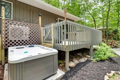 a deck with a hot tub next to a house at Near Skiing and Hiking Gouldsboro Home with Hot Tub in Gouldsboro