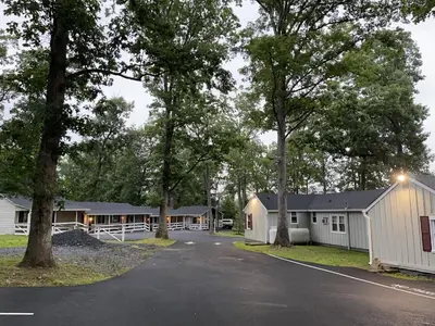a row of mobile homes on a street with trees at New Hope Lodge in New Hope