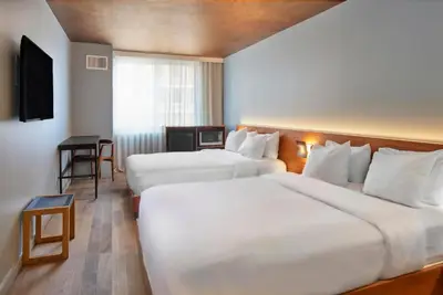 a hotel room with two beds and a desk at Truss Hotel Times Square in New York