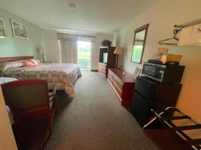 a hotel room with two beds and a television at Colonial Brick Inn & Suites in Susquehanna