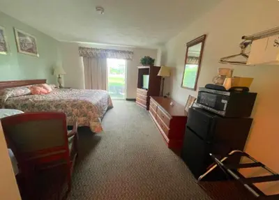 a hotel room with a bed and a television at Colonial Brick Inn & Suites in Susquehanna