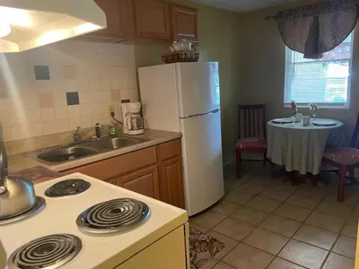 a kitchen with a stove and a white refrigerator at Colonial Brick Inn & Suites in Susquehanna