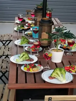 a wooden table with plates of food and wine glasses at THE ROOFTOP OASIS in Philadelphia