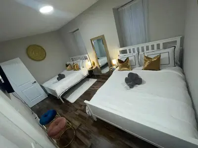 a bedroom with two white beds and two mirrors at THE ROOFTOP OASIS in Philadelphia