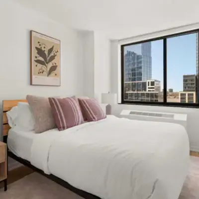 a white bedroom with a large bed and a window at Family Apartment in Excellent Sector of New York in New York