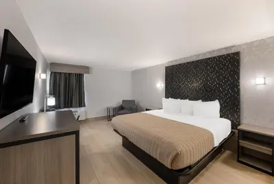a hotel room with a bed and a flat screen tv at Essence Express Wayne in Wayne