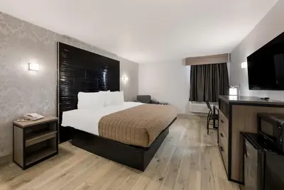 a hotel room with a bed and a flat screen tv at Essence Express Wayne in Wayne