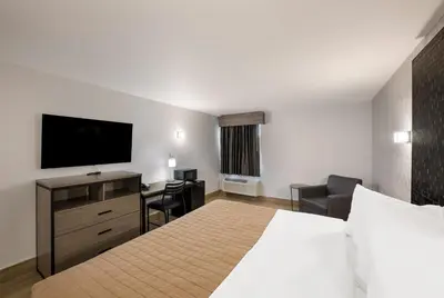 a hotel room with a bed and a flat screen tv at Essence Express Wayne in Wayne