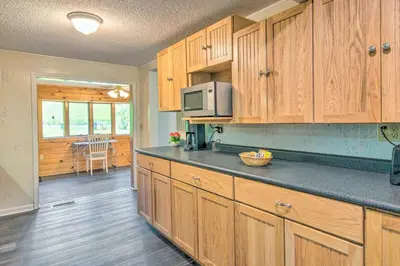 a kitchen with wooden cabinets and a counter top at River Views and Covered Deck Susquehanna Home! in Susquehanna