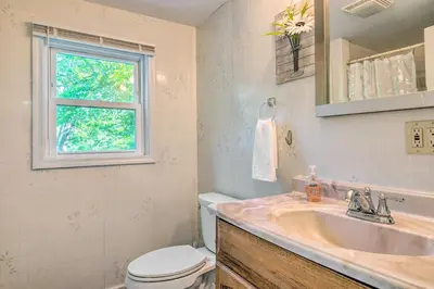 a bathroom with a sink and a toilet and a window at River Views and Covered Deck Susquehanna Home! in Susquehanna