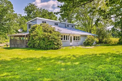 a house on a grassy field with a tree at River Views and Covered Deck Susquehanna Home! in Susquehanna