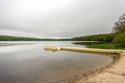 a large body of water with a dock in the water at Sweetfern Gouldsboro Cabin Deck and Lake Access in Gouldsboro