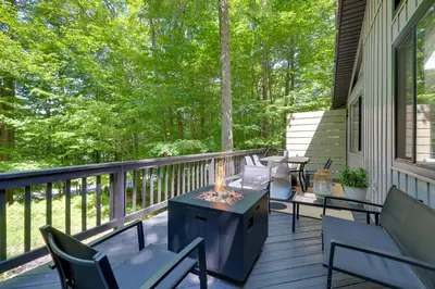 a screened porch with a fire pit and chairs at Sweetfern Gouldsboro Cabin Deck and Lake Access in Gouldsboro
