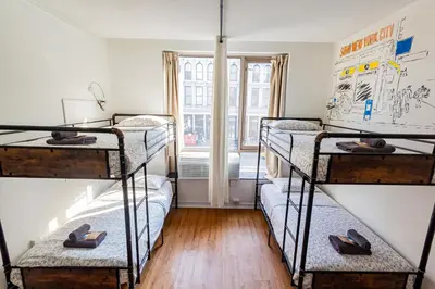 a room with four bunk beds with shoes on the floor at JG Sohotel in New York