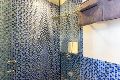 a bathroom with a shower with blue tiles at JG Sohotel in New York