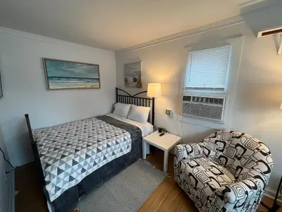 a small bedroom with a bed and a chair at Cobmin Ridge Motel in Branchville