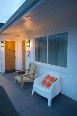 a porch with a chair and a bench on a house at Cobmin Ridge Motel in Branchville