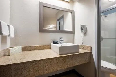 a bathroom with a sink and a mirror at HomeTowne Studios by Red Roof Princeton - Ewing/ Lawrenceville in Trenton