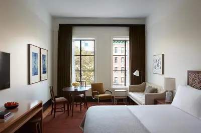 a hotel room with a bed and a table and chairs at Nine Orchard in New York