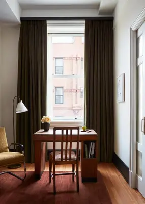 a dining room table with a chair and a window at Nine Orchard in New York