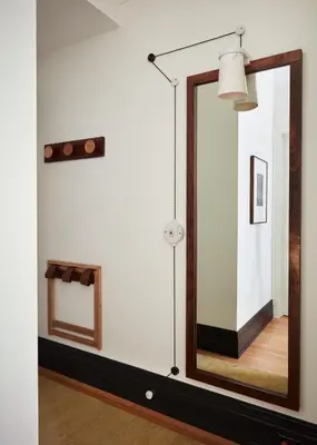 a mirror on a wall in a room with a lamp at Nine Orchard in New York