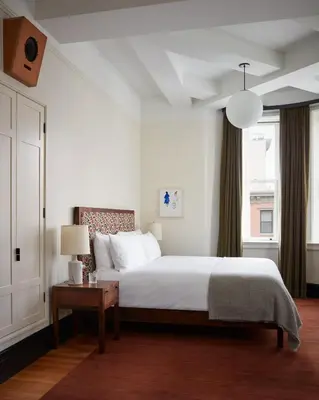 a bedroom with a bed and a table and a window at Nine Orchard in New York