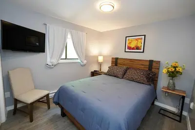 a bedroom with a bed and a chair and a television at A gorgeous home, 5BR-2BT, perfect for your family! in Tobyhanna