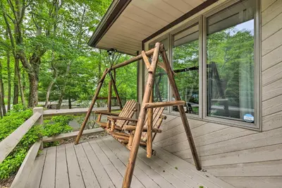 a porch with a swinging chair on a house at Near Hiking and Skiing Albrightsville Home with Deck! in Albrightsville