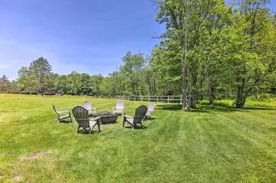 a group of chairs and a table in a field at Poconos Cottage with Fire Pit Near Lake Harmony in Albrightsville