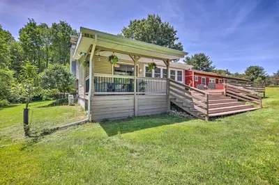 a house with a large porch and a fence at Poconos Cottage with Fire Pit Near Lake Harmony in Albrightsville