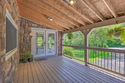 a porch with a wooden deck with a door at Poconos Cottage with Fire Pit Near Lake Harmony in Albrightsville