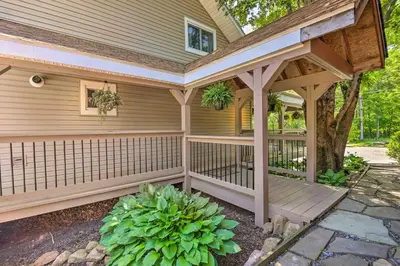 a wooden pergola attached to a house at Poconos Cottage with Fire Pit Near Lake Harmony in Albrightsville
