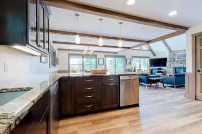 a kitchen with wooden cabinets and a living room at Harmony House in Lake Harmony