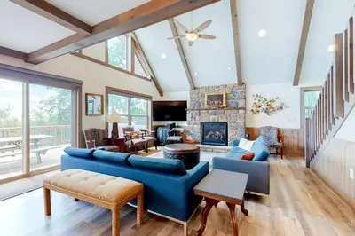 a living room with a blue couch and a fireplace at Harmony House in Lake Harmony
