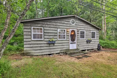 a small house with two windows and a door at Cabin with Trails and Creek! 23 Mi to Camelback Slopes in Greentown