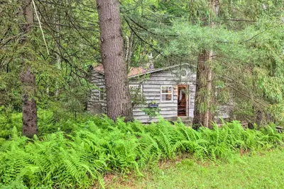 a small house in the middle of a forest at Cabin with Trails and Creek! 23 Mi to Camelback Slopes in Greentown