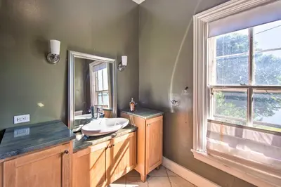 a bathroom with a sink and a mirror and a window at 1 Mi to Dtwn Historic Harrisburg Home in Harrisburg