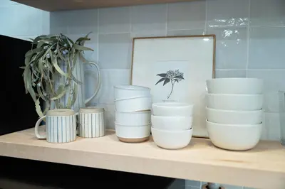 a shelf with white cups and a potted plant at The Loft at Woodhaven Hideaway in Myerstown