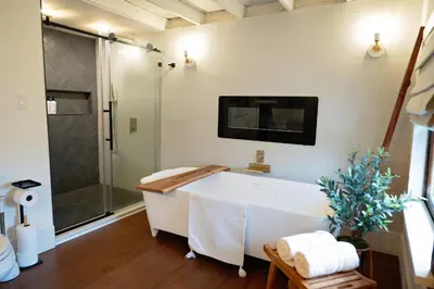 a bathroom with a tub and a tv on the wall at The Loft at Woodhaven Hideaway in Myerstown