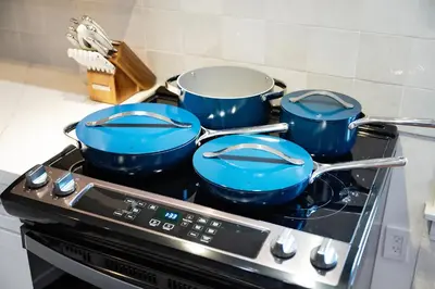 three blue pots and pans sitting on top of a stove at The Loft at Woodhaven Hideaway in Myerstown